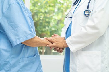 Caregiver holding hands Asian elderly woman patient with love, care, encourage and empathy at nursing hospital, healthy strong medical concept.
