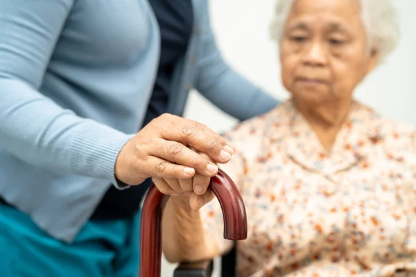 Caregiver help Asian elderly woman patient with love, care, encourage and empathy at nursing hospital, healthy strong medical concept.