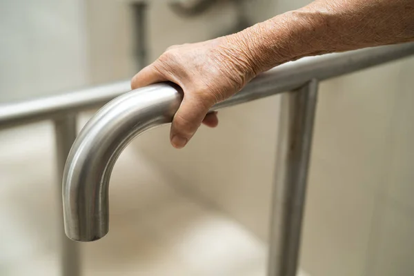 Asian elderly woman patient use toilet bathroom handle security in nursing hospital, healthy strong medical concept.