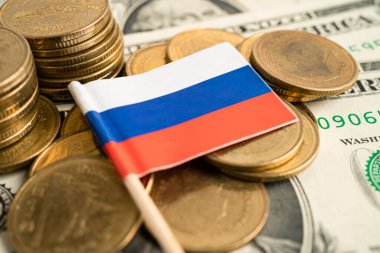 Beyaz arkaplanda Rusya bayrağı olan bozuk para yığını.