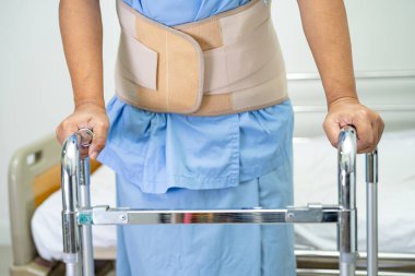 Asyalı hasta yürümeyi desteklemek için hastanede Walker kullanıyor..