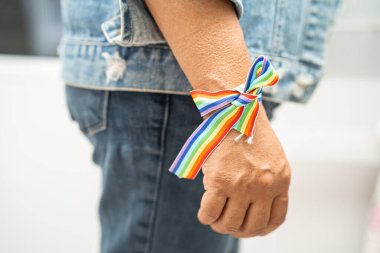 Gökkuşağı bilekliği takan Asyalı kadın, LGBT onur ayının sembolü Haziran sosyal ortamında gey, lezbiyen, biseksüel, transseksüel, insan hakları.