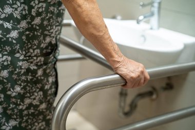 Asyalı yaşlı kadın tuvalet temizliği kullanıyor. Sağlıklı, güçlü bir tıbbi konsept..