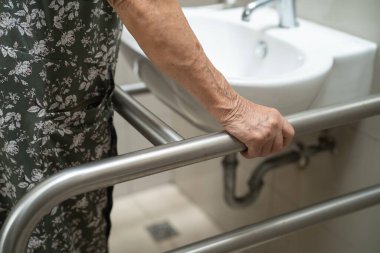 Asyalı yaşlı kadın hasta hemşire hastanesinde tuvalet temizliği yapıyor. Sağlıklı, güçlü bir tıbbi konsept..