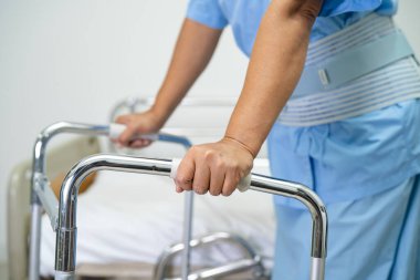 Asyalı hasta yürümeyi desteklemek için hastanede Walker kullanıyor..