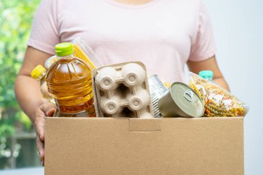 Gönüllüler insanlara yardım etmek için çeşitli kuru yiyecekleri bağış kutusuna koyuyorlar..