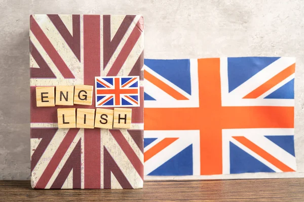 Word English on book with United Kingdom flag, learning English language courses concept.