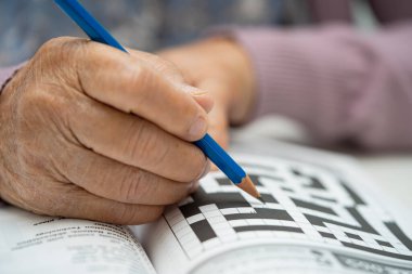 Alzheimer hastalığı AD, Asyalı yaşlı kadın bunama için beyin eğitimi için sudoku bulmacası oynuyor.