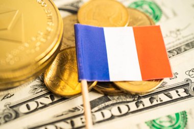 Stack of coins with France flag and US dollar banknotes.