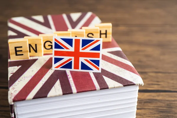 Word English on book with United Kingdom flag, learning English language courses concept.