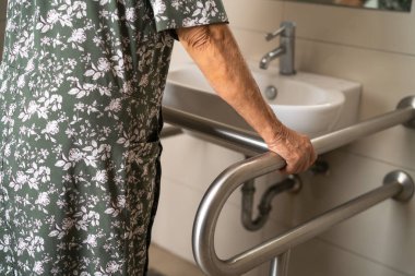 Asyalı yaşlı kadın hasta, hemşire hastanesinde tuvalet temizliği yapıyor. Sağlıklı ve güçlü bir tıbbi konsept..