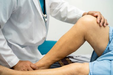 Asyalı yaşlı kadın hasta yaralarını gösteriyor. Diz eklemi, eklem protezi, hastanede yatakta eklem iltihabı, sağlıklı güçlü tıbbi konsept..