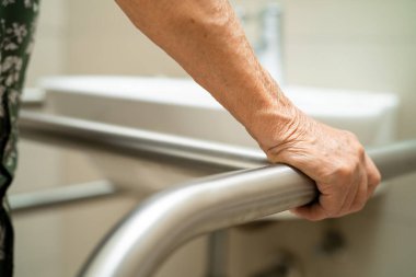 Asyalı yaşlı kadın hasta, hemşire hastanesinde tuvalet temizliği yapıyor. Sağlıklı ve güçlü bir tıbbi konsept..