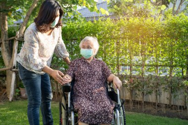 caregiver help and care Asian senior woman patient sitting on wheelchair at nursing hospital ward, healthy strong medical concept.