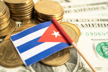 Küba bayrağı ve Amerikan doları banknotları olan bozuk paralar yığını.
