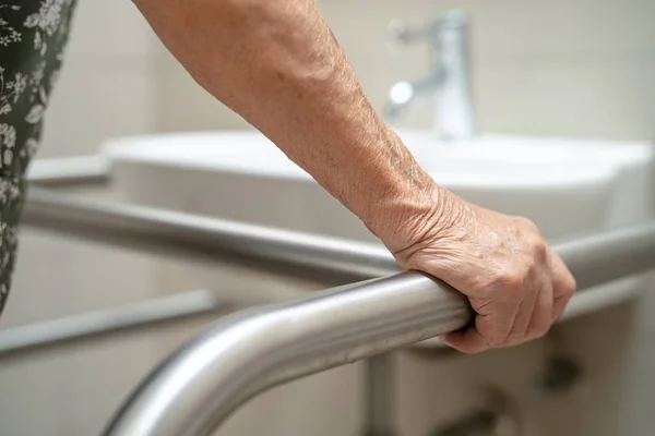 stock image Asian elderly woman patient use toilet bathroom handle security in nursing hospital, healthy strong medical concept.