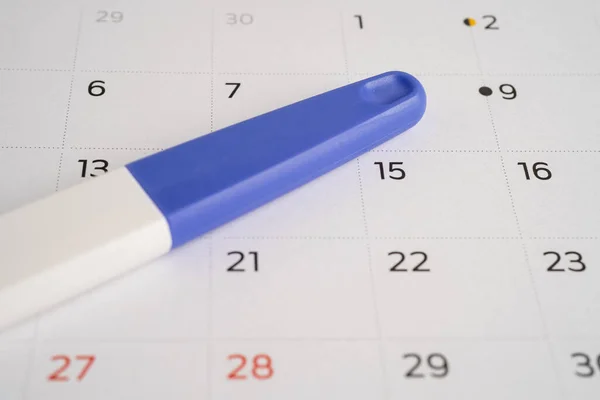 Pregnancy test on calendar, contraception health and medicine.