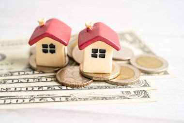 Madeni para, ev kredisi, tasarruf planı, taksitlendirme finansmanı ve bankacılık kavramı üzerinde bitki yetiştiren ev modeli.