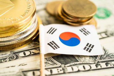 Kore bayrağı ve Amerikan doları banknotları olan bozuk para yığını..