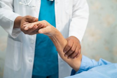 Doktor, hastayı kontrol etmek için steteskop kullanıyor. Hastanedeki bir yatağa uzanıyor. Sağlıklı, güçlü bir tıbbi konsept..