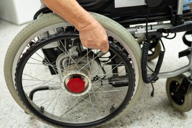 Asian senior woman patient on electric wheelchair with remote control at hospital, healthy strong medical concept.