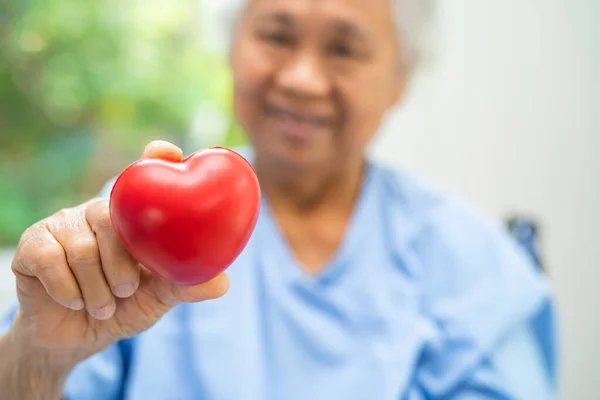 Doctor holding a red heart in hospital, healthy strong medical concept.