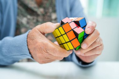 Bangkok, Tayland 14 Ağustos, 2023 Alzheimer Hastalığı AD, Asyalı yaşlı kadın hasta bunama için beyin eğitimi için Rubik küp oyunu oynuyor..