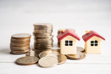 Madeni para, ev kredisi, tasarruf planı, taksitlendirme finansmanı ve bankacılık kavramı üzerinde bitki yetiştiren ev modeli.