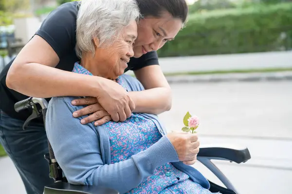 Caregiver help and care Asian senior woman patient sitting on wheelchair, healthy strong medical concept.