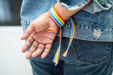 Gökkuşağı bilekliği takan Asyalı kadın, LGBT onur ayının sembolü Haziran sosyal ortamında gey, lezbiyen, biseksüel, transseksüel, insan hakları.