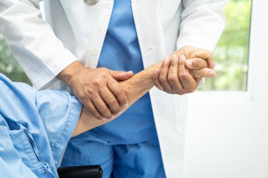 Caregiver holding hands Asian elderly woman patient with love, care, encourage and empathy at nursing hospital, healthy strong medical concept.