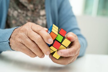Bangkok, Tayland 14 Ağustos, 2023 Alzheimer Hastalığı AD, Asyalı yaşlı kadın hasta bunama için beyin eğitimi için Rubik küp oyunu oynuyor..