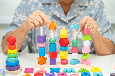 Alzheimer Hastalığı AD, bunama geçiren Asyalı yaşlı kadın hasta pratik motor beceri rehabilitasyonu öğreniyor.