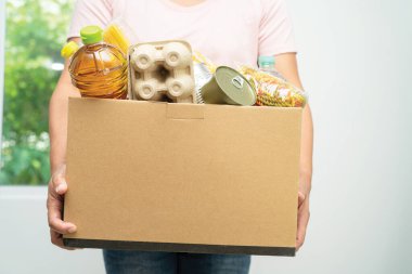 Gönüllüler insanlara yardım etmek için çeşitli kuru yiyecekleri bağış kutusuna koyuyorlar..