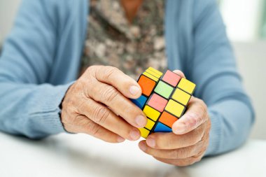 Bangkok, Tayland 14 Ağustos, 2023 Alzheimer Hastalığı AD, Asyalı yaşlı kadın hasta bunama için beyin eğitimi için Rubik küp oyunu oynuyor..