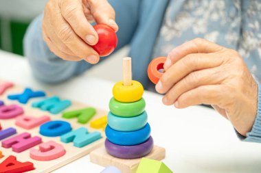 Alzheimer Hastalığı AD, bunama geçiren Asyalı yaşlı kadın hasta pratik motor beceri rehabilitasyonu öğreniyor.