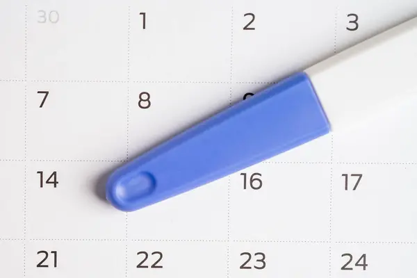 Pregnancy test for birth control on calendar, contraception health and medicine.
