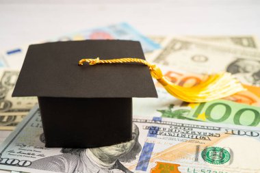 Avrupa ve ABD doları üzerindeki mezuniyet şapkası para, eğitim ücreti öğrenim öğrenimi öğretim konsepti.