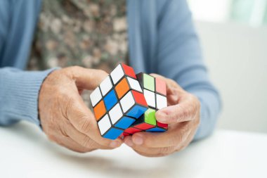 Bangkok, Tayland 14 Ağustos, 2023 Alzheimer Hastalığı AD, Asyalı yaşlı kadın hasta bunama için beyin eğitimi için Rubik küp oyunu oynuyor..