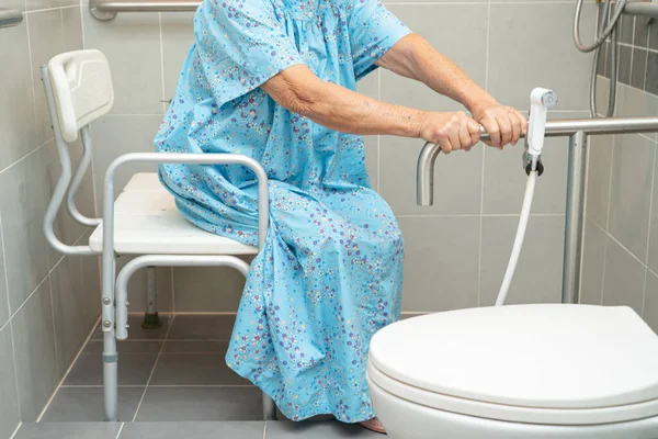 stock image Asian elderly woman patient use toilet bathroom handle security in nursing hospital, healthy strong medical concept.