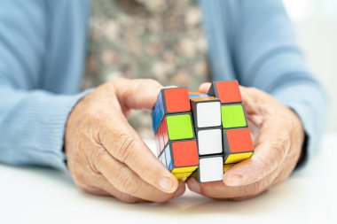 Bangkok, Tayland 14 Ağustos, 2023 Alzheimer Hastalığı AD, Asyalı yaşlı kadın hasta bunama için beyin eğitimi için Rubik küp oyunu oynuyor..
