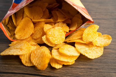 Patates cipsi, leziz BBQ baharatlı Crips için ince dilimlenmiş kızarmış abur cubur açık poşette fast food..