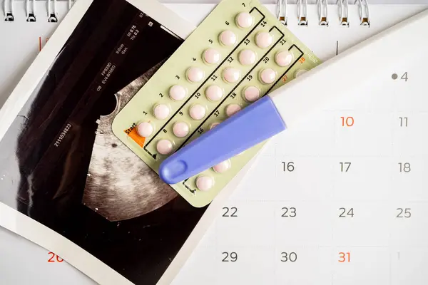 Pregnancy test and birth control pills with ultrasound scan of baby uterus, contraception health and medicine.