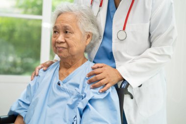 Doktor yardımı ve bakımı, hastanede tekerlekli sandalyedeki Asyalı yaşlı kadın..