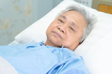 Hastanede yatan Asyalı yaşlı kadın hasta, sağlıklı güçlü tıbbi konsept..