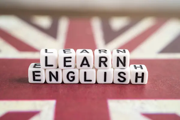 Word Learn English on book with United Kingdom flag, learning English language courses concept.