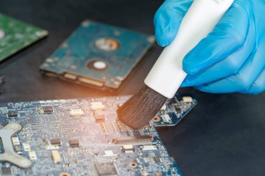Asyalı teknisyen fırça, donanım, cep telefonu, güncelleme konsepti ile akıllı telefon elektronik teknolojisinin kirli mikro devre tamiri ve temizliği.
