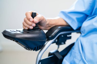 Asian senior woman patient on electric wheelchair with remote control at hospital, healthy strong medical concept.