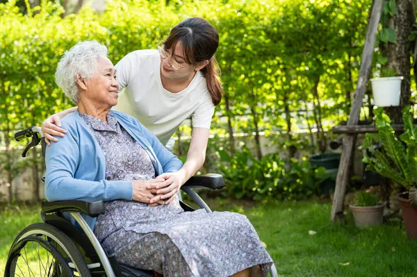 caregiver help and care Asian senior woman patient sitting on wheelchair at nursing hospital ward, healthy strong medical concept.