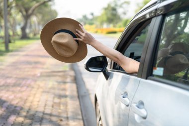 Yaz tatilinde el kaldırarak ve arabanın önünde şapka tutarak seyahat etmenin keyfini çıkarın..